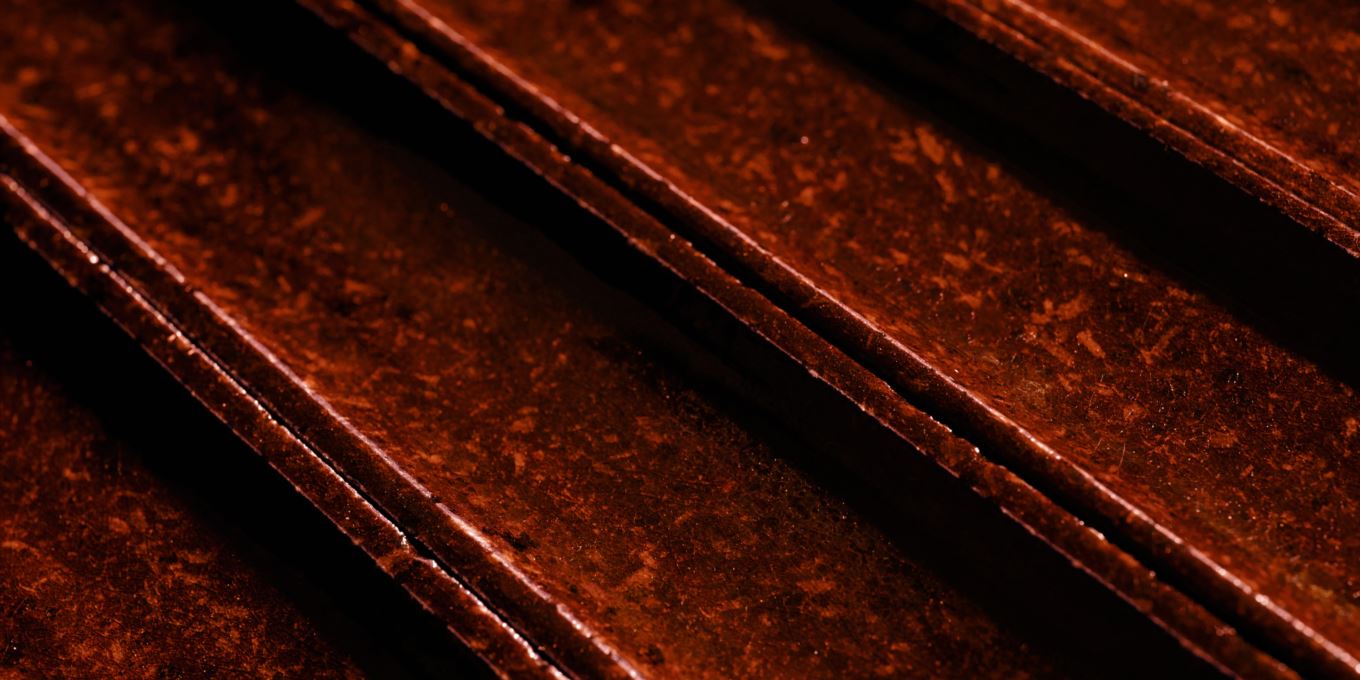 Glazed lava stone surface texture detail — deep burgundy 3D finish by Ranieri